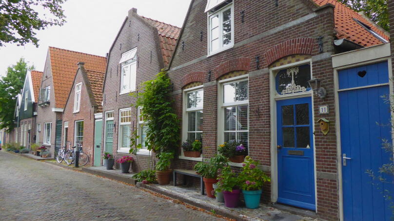 Quaint village houses with blooming flowers and plants in Edam, Netherlands, showcasing traditional Dutch architecture