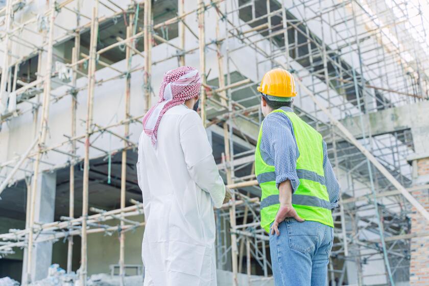 engineer standing with arub property investor looking under construction building for new properties  projects in middle east country