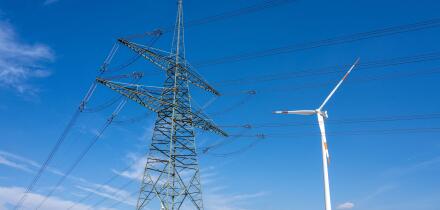 An electricity pylon with wind turbines seen in Germany
