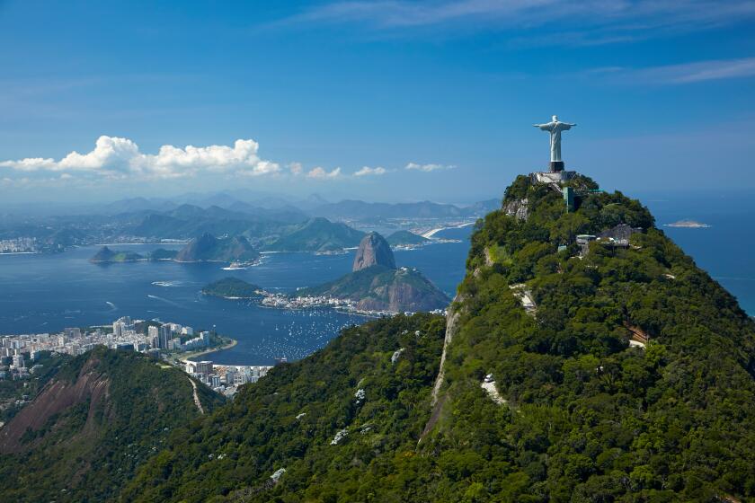 Christ the Redeemer statue atop Corcovado, and Sugarloaf Mountain, Rio de Janeiro, Brazil, South America - aerial