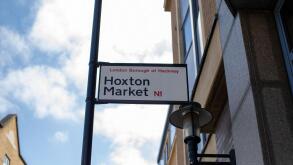 Street sign for Hoxton Market in the London Borough of Hackney under a clear sky.