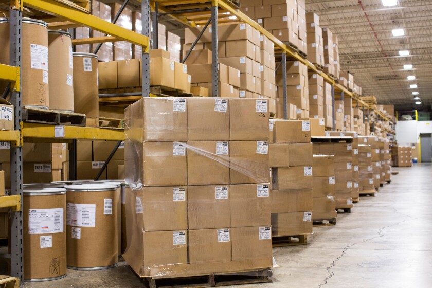 An industrial warehouse full of cardboard boxes on shelving. 