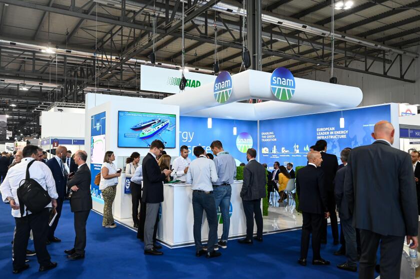MILAN, ITALY - SEPTEMBER 6, 2022: a view of the Snam stand during Gastech 2022 trade show event in Milan Fair. Visitors and people in the hall walk through exhibitors stands and exhibit booths.