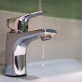 Traditional silver tap dripping. Broken faucet in the tub dripping water. Leaking plumbing. Wasteful water consumption. the concept of saving water.