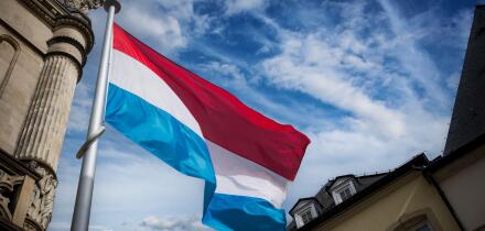 Luxembourg flag flying among historic buildings in the capital
