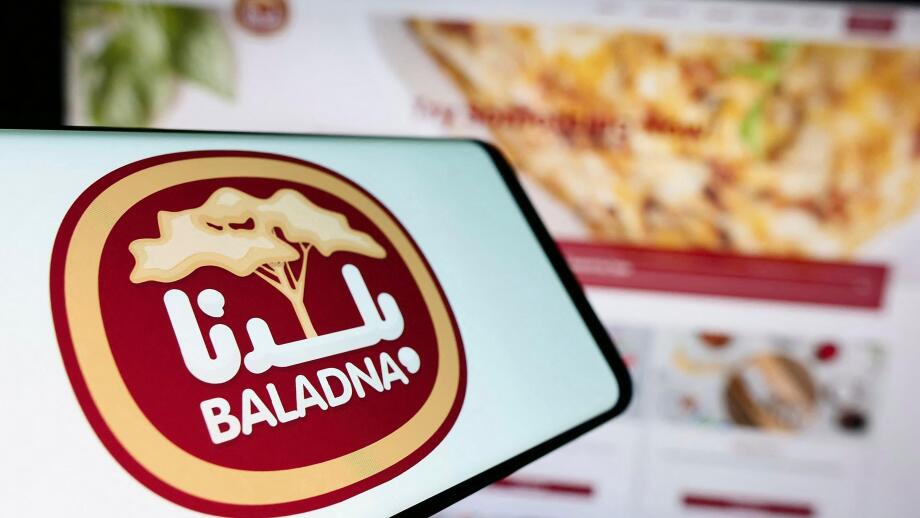 Stuttgart, Germany, 11-03-2023: Person holding cellphone with logo of Qatari dairy and food company Baladna in front of business website. Focus on