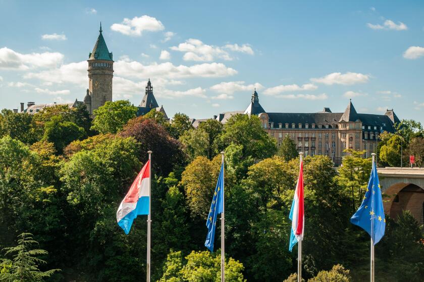 Musee de la Banque (Bank Museum, left) and State Bank and Savings Fund buildings with Luxembourg and EU flags in the foreground, Luxembourg City.