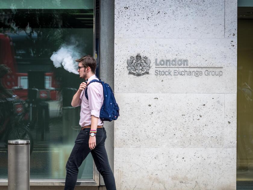London Stock Exchange LSE - A city worker exhales vapour while passing the London Stock Exchange offices in the City of London, UK