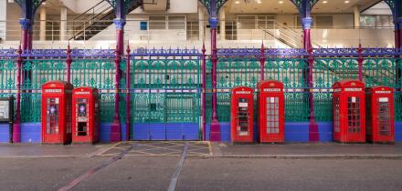 Red phone boxes next to the colourful fence of Smithfield Market